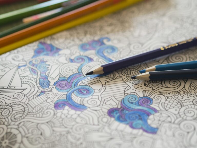 Coloring book with vibrant pencils enhancing intricate designs, perfect for creativity.