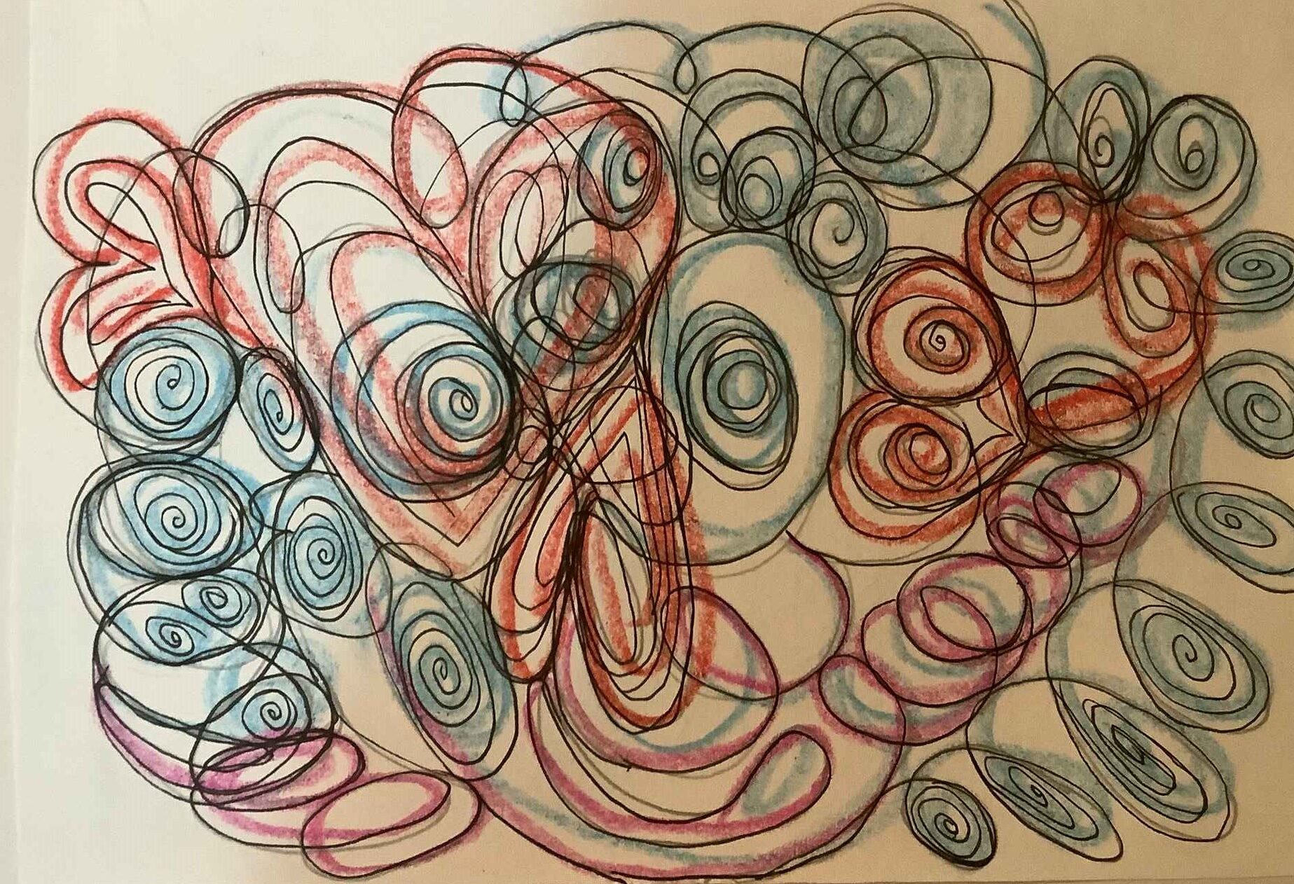 A hand holding an open journal with a detailed mandala drawing outdoors.